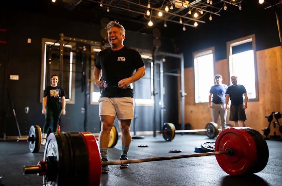 Athletes smiling between lifts during a group training session